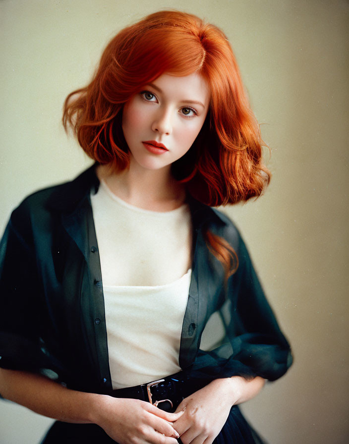 Vibrant red-haired woman in white top against cream background