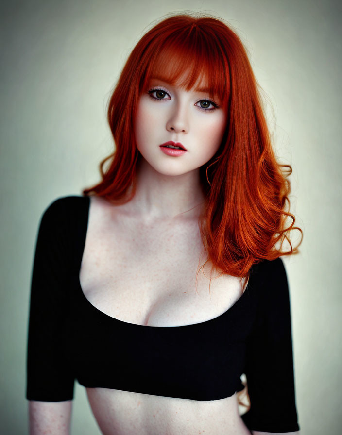 Red-haired woman in black top with bangs staring at camera