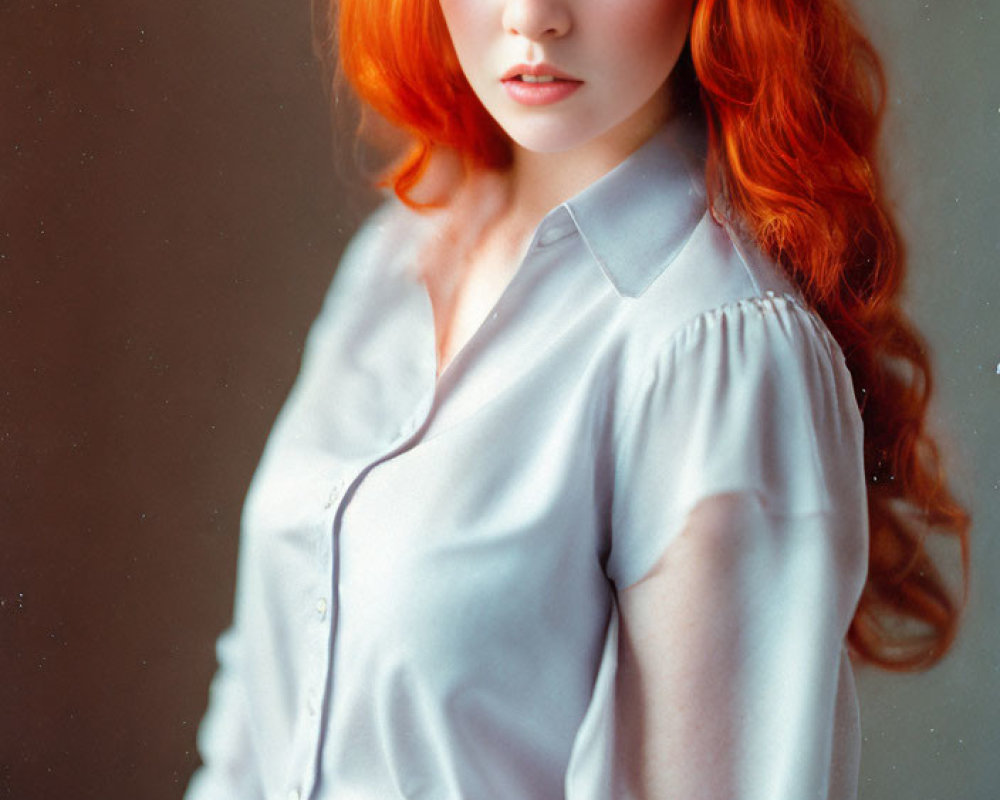 Long Red-Haired Woman in Blue Shirt Poses with Soft Lighting