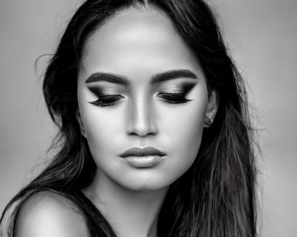 Monochrome portrait of woman with closed eyes and eyeliner, full lips, and flowing hair