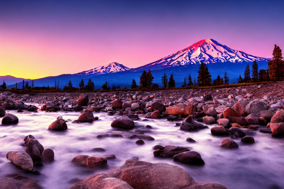 Scenic sunset with purple and orange hues over snowy mountain and flowing river