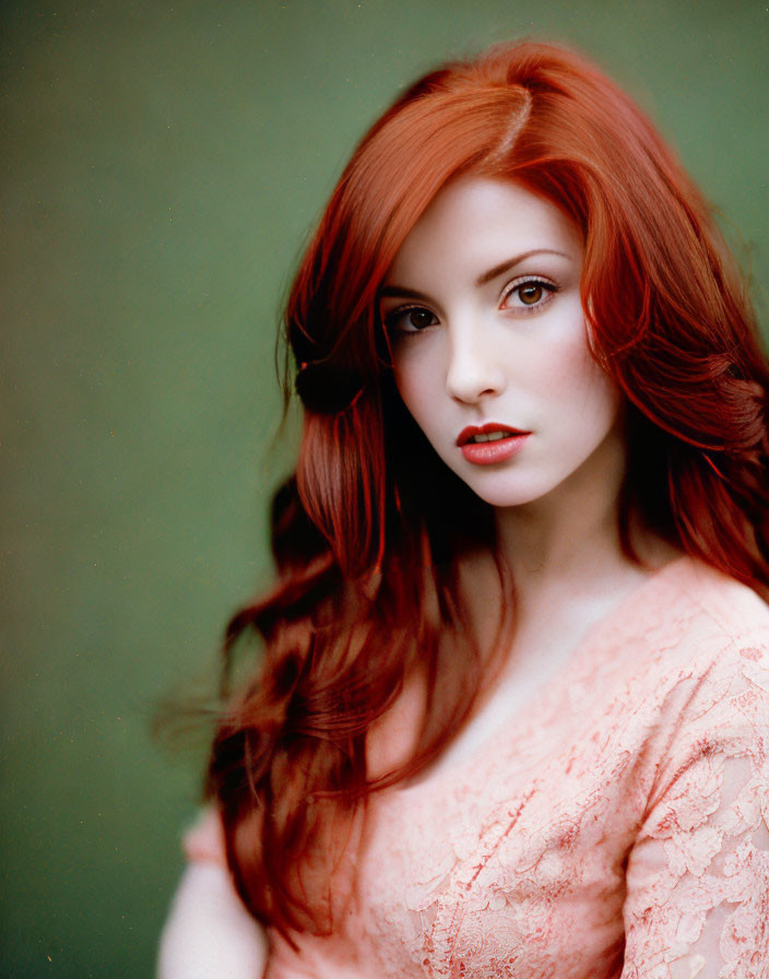 Red-haired woman in pink lace outfit against green background