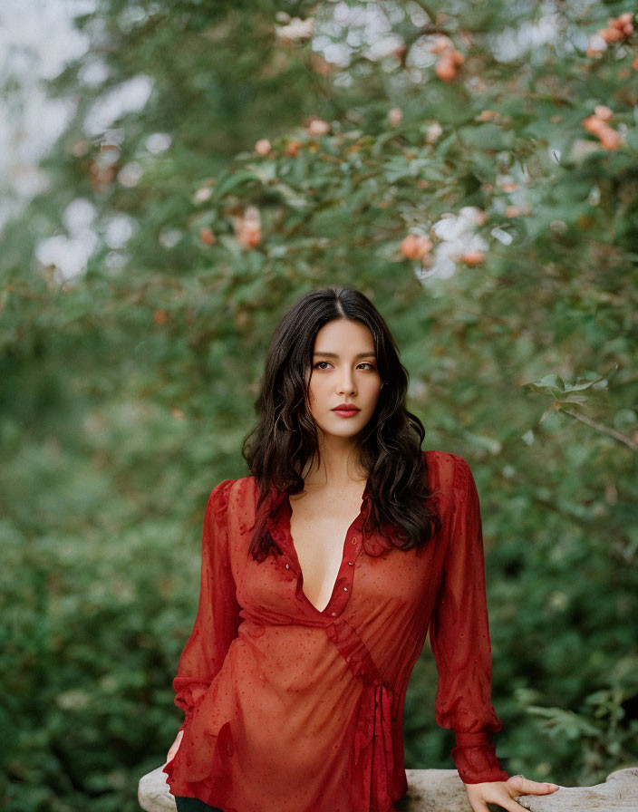 Woman in Red Dress Standing by Fruit Tree in Serene Setting