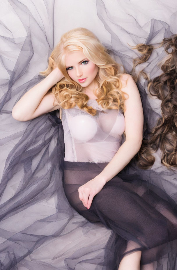 Blonde Woman Posing in Flowing Fabric on Light Background