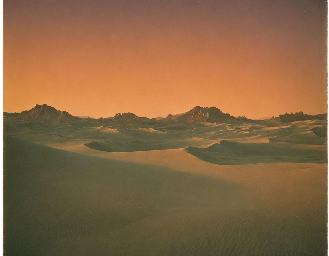 Sunset over desert landscape with sand dunes and mountains