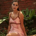 Smiling woman in pink floral dress in garden setting