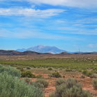 Tranquil desert landscape with buttes under blue sky