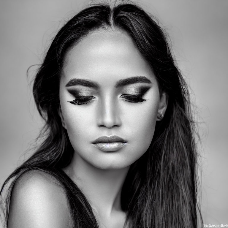 Monochrome portrait of woman with closed eyes and eyeliner, full lips, and flowing hair