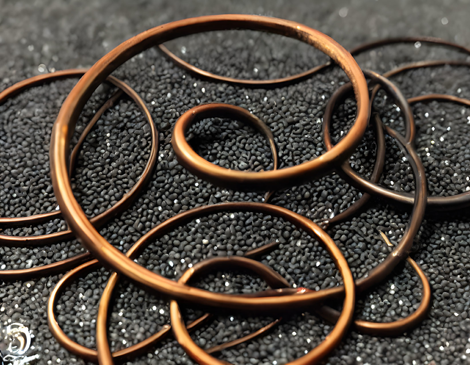 Copper rings with black beads on matte background