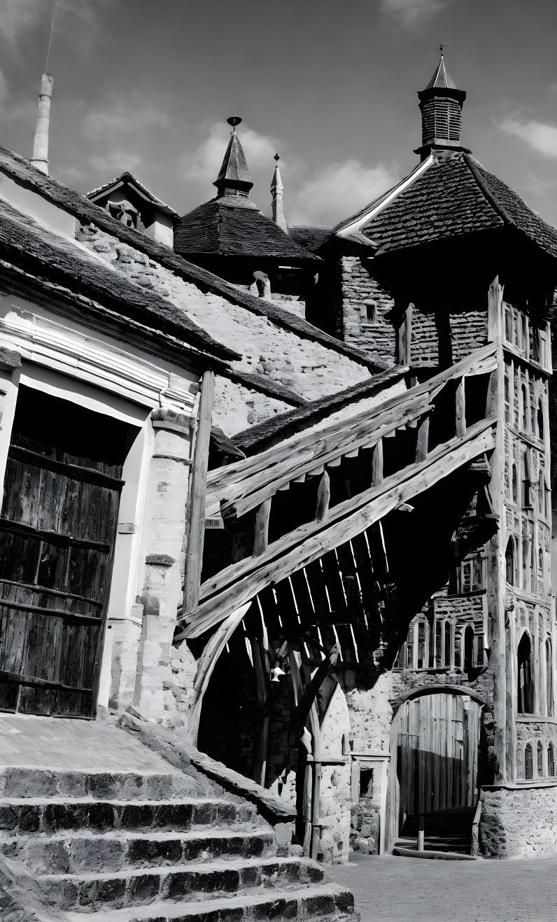 Monochrome image of old staircase to wooden building with turrets