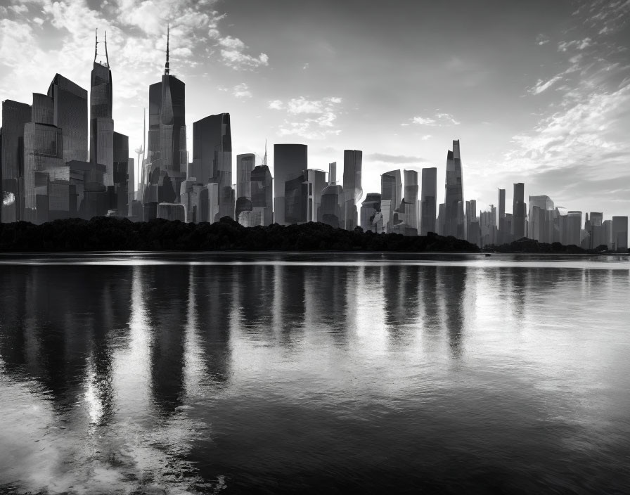 Grayscale city skyline with skyscrapers reflected on calm water