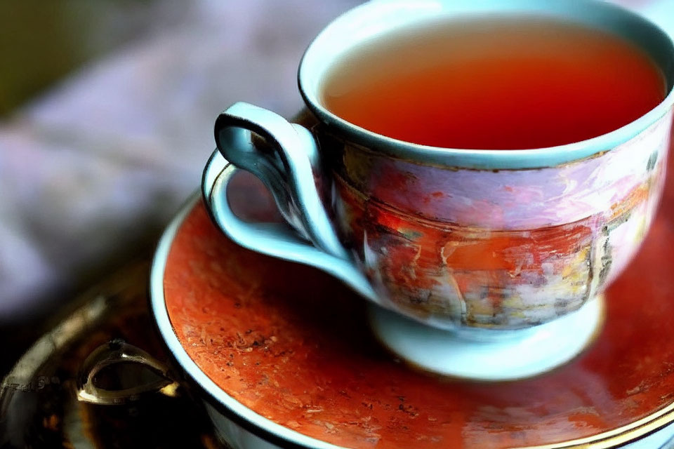 Colorful Ceramic Teacup and Saucer Filled with Tea