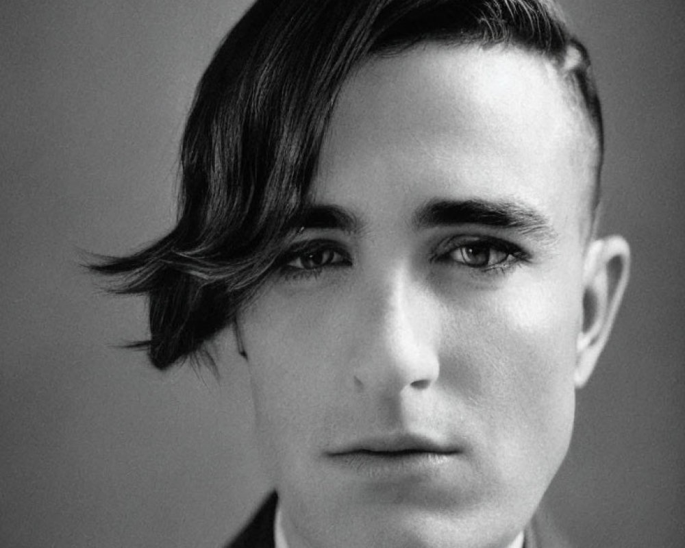 Monochrome portrait of young man in suit with side-parted hair