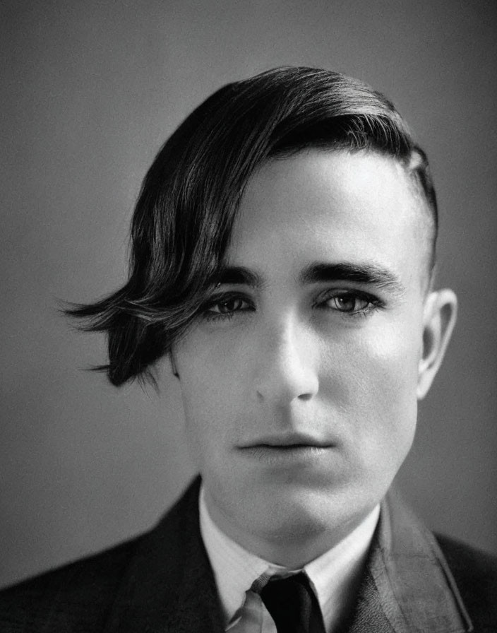 Monochrome portrait of young man in suit with side-parted hair