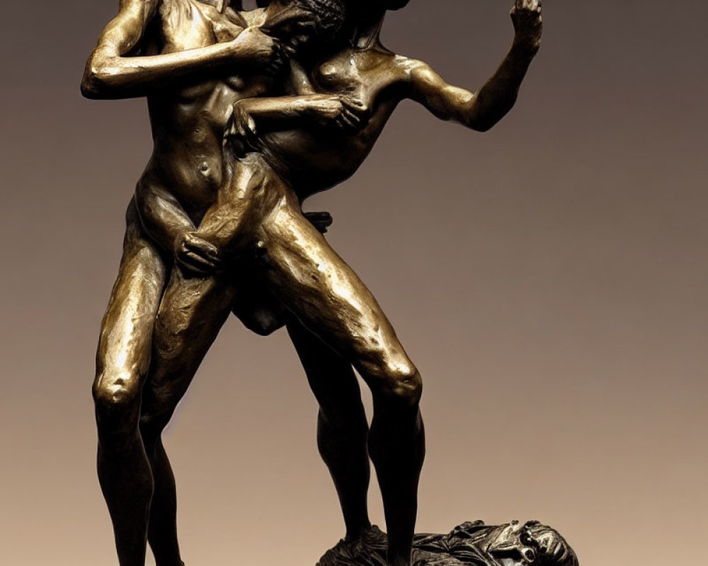 Dynamic bronze statue of intertwined figures in emotional pose on warm background