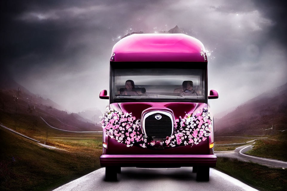 Pink bus with floral design drives on winding road amidst mountainous landscape