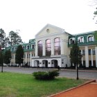 Person on Brick Path Observing Neoclassical Building and Greenery