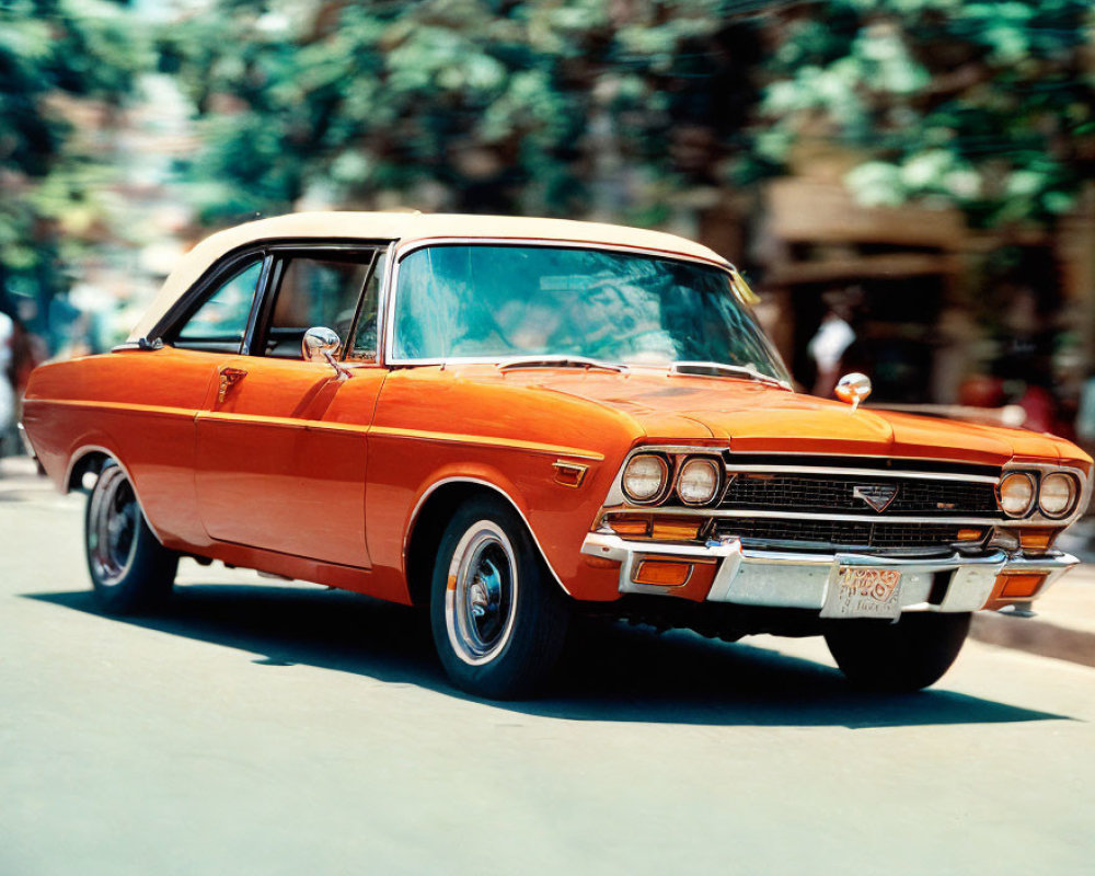 Vintage orange car with chrome grille and white-wall tires parked on street