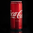 Condensation beads on Coca-Cola can under dramatic lighting