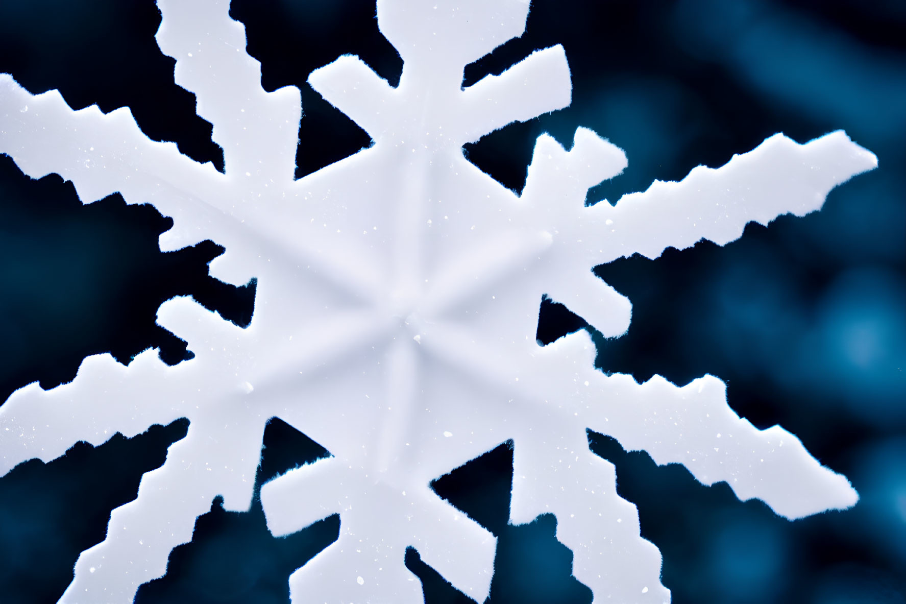 Detailed Close-Up of Intricate White Snowflake on Blur Blue Background