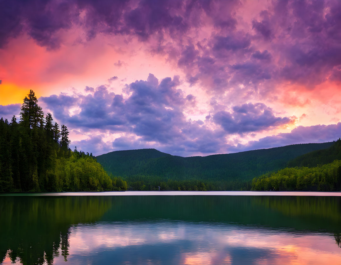 Scenic sunset: pink and purple clouds over serene lake, forest, hills