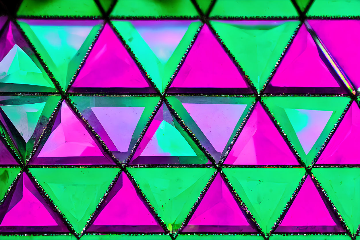 Colorful geometric triangular stained glass window in pink and green.