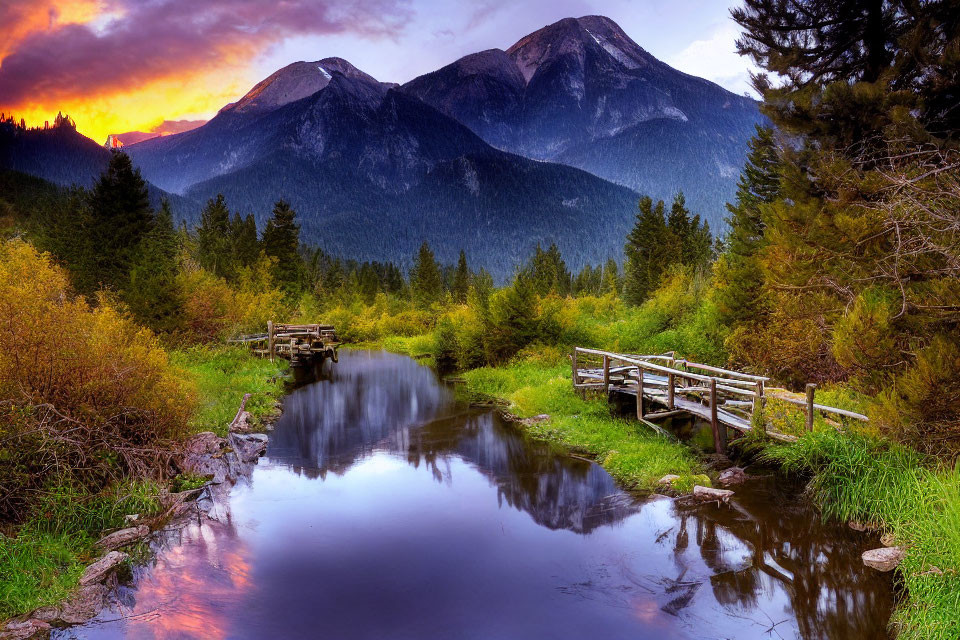 Tranquil landscape with wooden bridge, stream, greenery, mountains, sunset