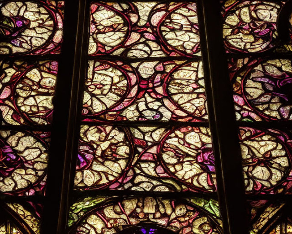 Intricate Gothic stained glass window with vibrant purple, red, and yellow colors