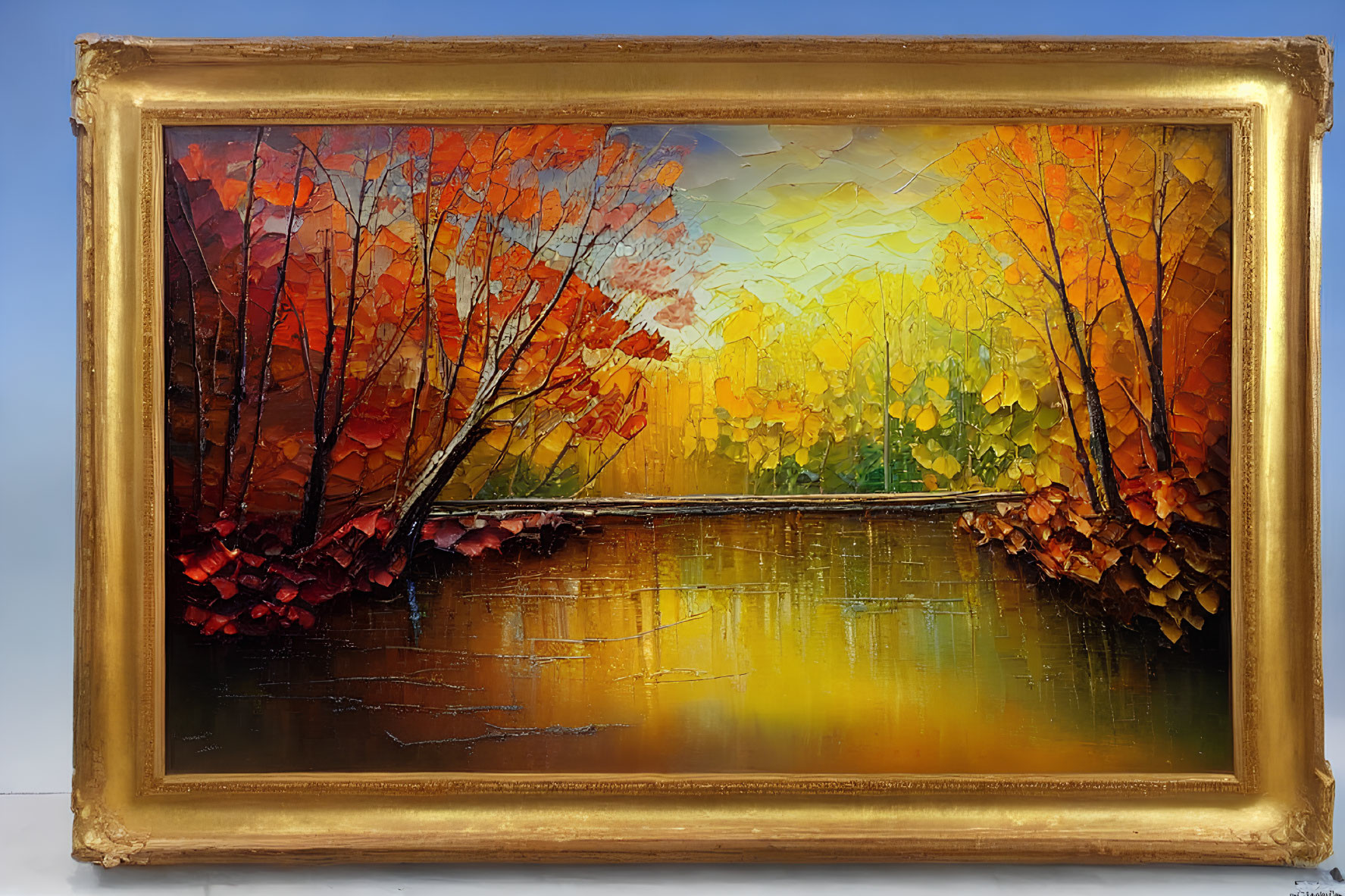 Colorful autumn trees painting with lake reflection in gold frame