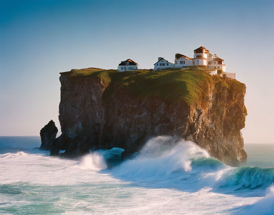 Cliffside houses with ocean waves crashing.