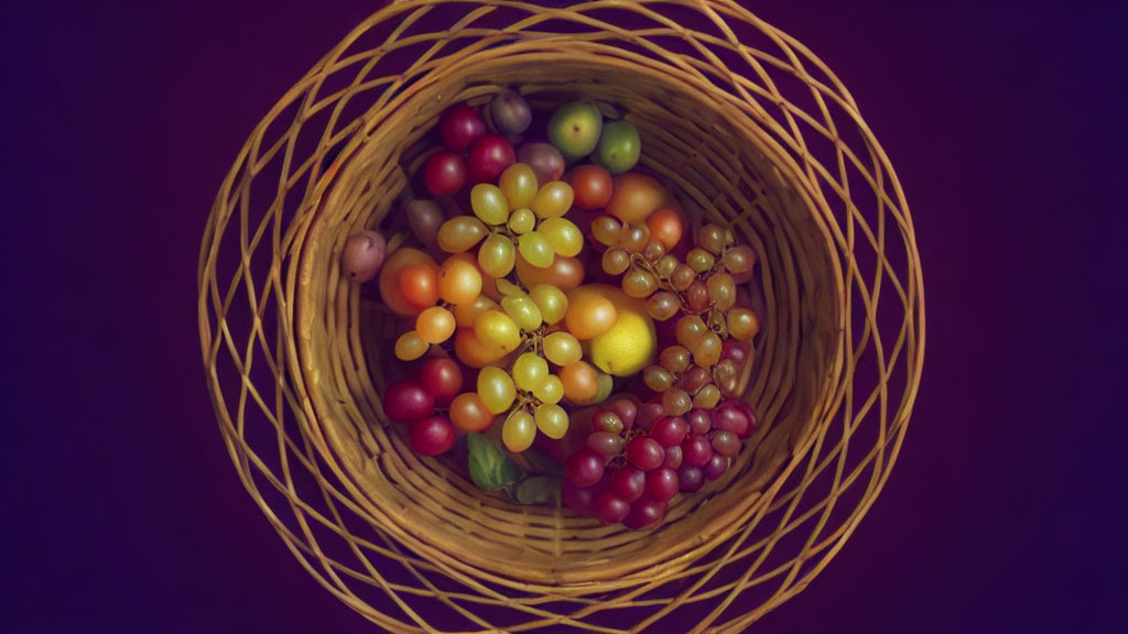 Colorful Grapes in Circular Basket on Dark Purple Background