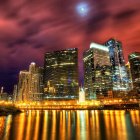 Golden illuminated buildings in futuristic cityscape at dusk with red sky and crescent moon.