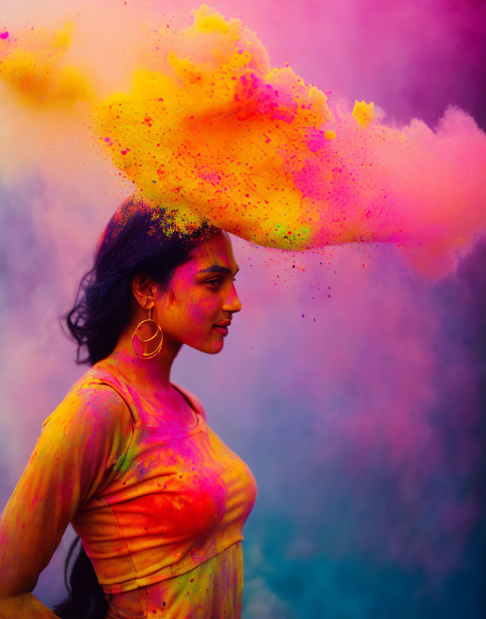 Colorful powder explosion above woman with joyful expression