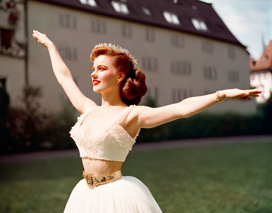 Woman in white dress and tiara poses joyfully outdoors