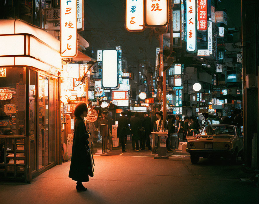Vivid nighttime street scene in Japan with neon signs, solitary figure, and classic car