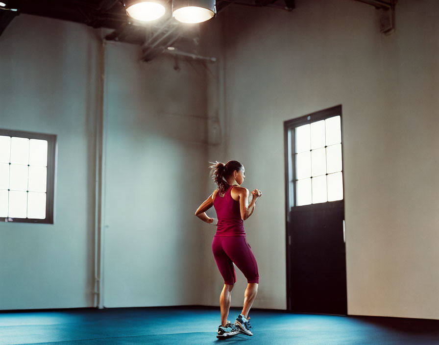 Woman in purple sportswear jogging in bright room