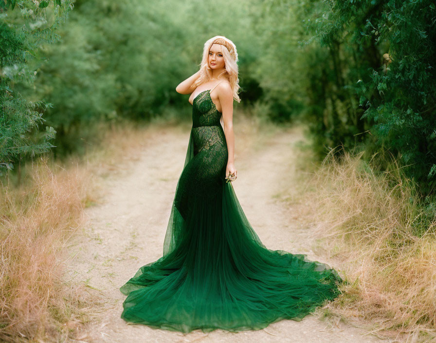 Woman in elegant green dress among lush greenery with loose curled hair