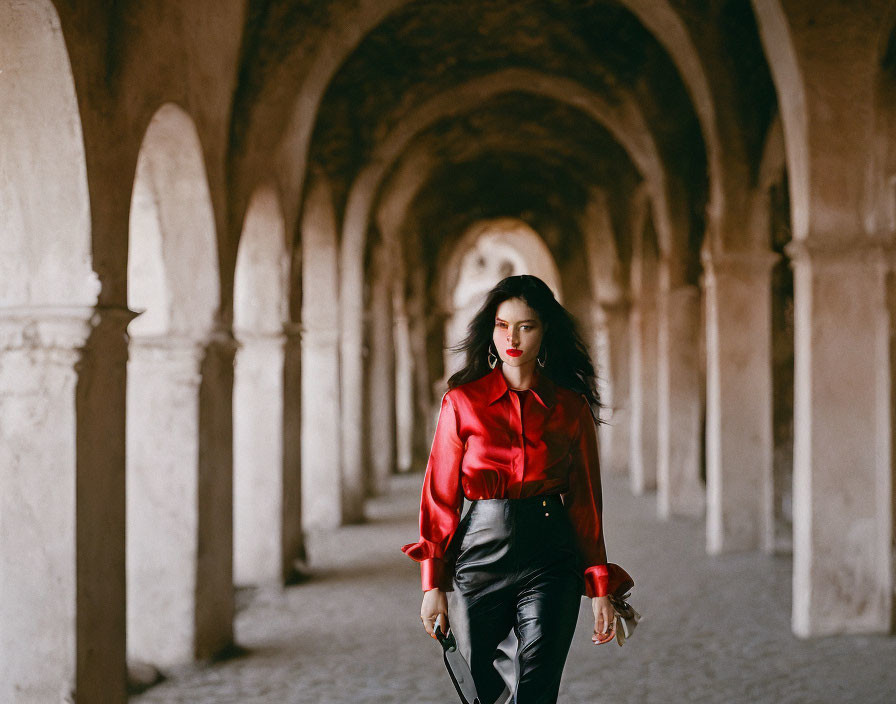 Woman in Red Blouse Walking Through Arched Corridor