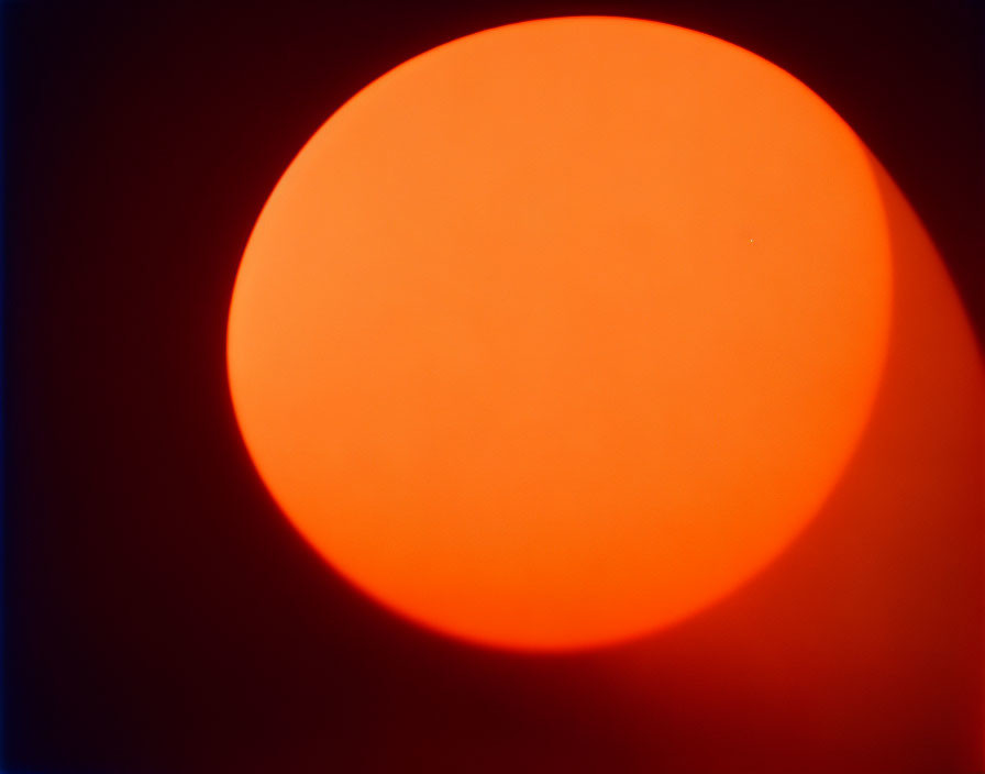 Glowing orange orb on dark red background