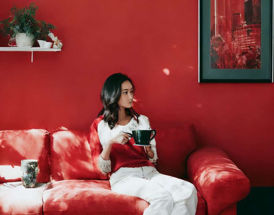 Woman on Red Couch with Coffee Cup and Framed Picture