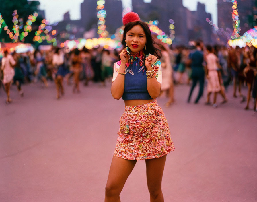 Colorfully dressed woman with red hat poses at busy festival with whistle