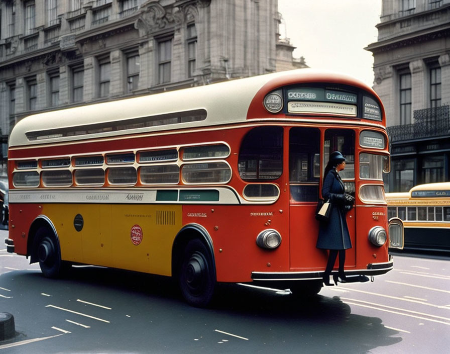 Vintage red and yellow double-decker bus with conductress at rear platform