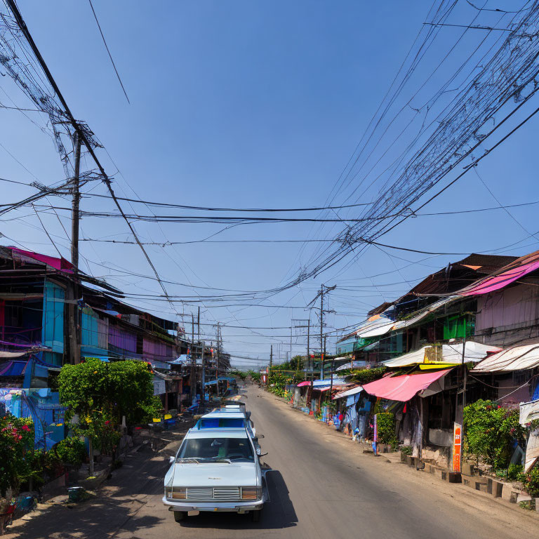 Vintage car driving on colorful street under sunny sky