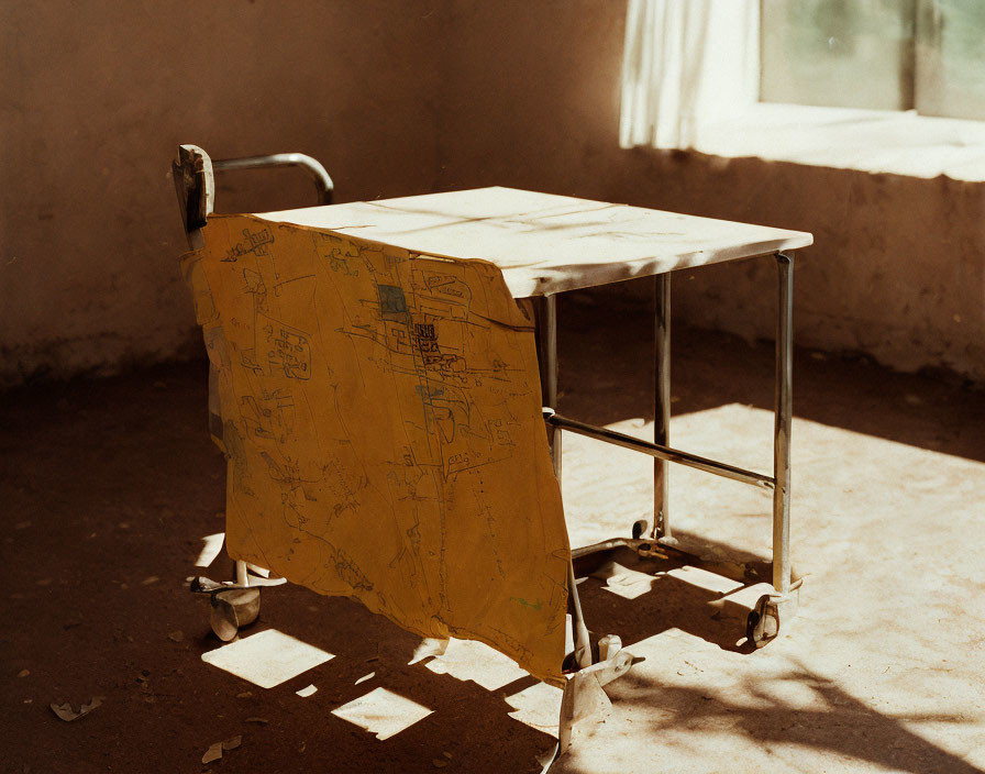 Weathered medical stretcher with torn yellow sheet in sunlit room