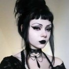 Striking Gothic Look with High Black Hair Bun & Bold Makeup