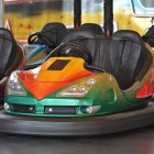 Vibrant indoor amusement park bumper cars with green and orange focus