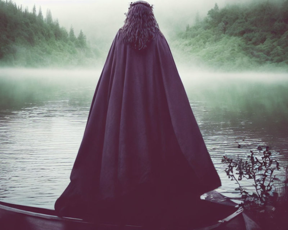 Cloaked Figure on Boat in Misty Lake with Forested Hills