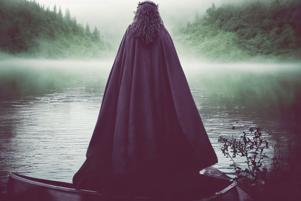 Cloaked Figure on Boat in Misty Lake with Forested Hills