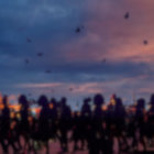 Blurred figures against colorful twilight sky on a beach