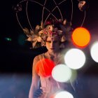 Portrait of woman with floral headpiece on abstract colorful background